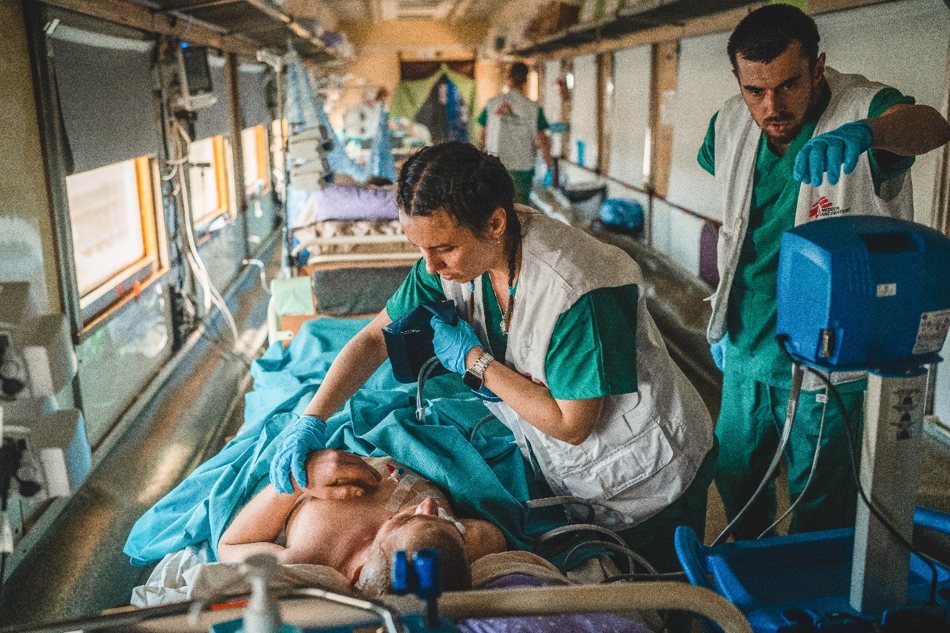 Doctors on Rails - AZG medische trein in Oekraïne - Het medisch team in de ’intensive care unit‘ (ICU) van de medische trein van AZG controleert en stabiliseert een zwaargewonde patiënt tijdens een reis van Pokrovsk in Oost-Oekraïne naar Lviv in West-Oekraïne. De reis duurt ongeveer 20 uur - 20/05/2022 - © Andrii Ovod