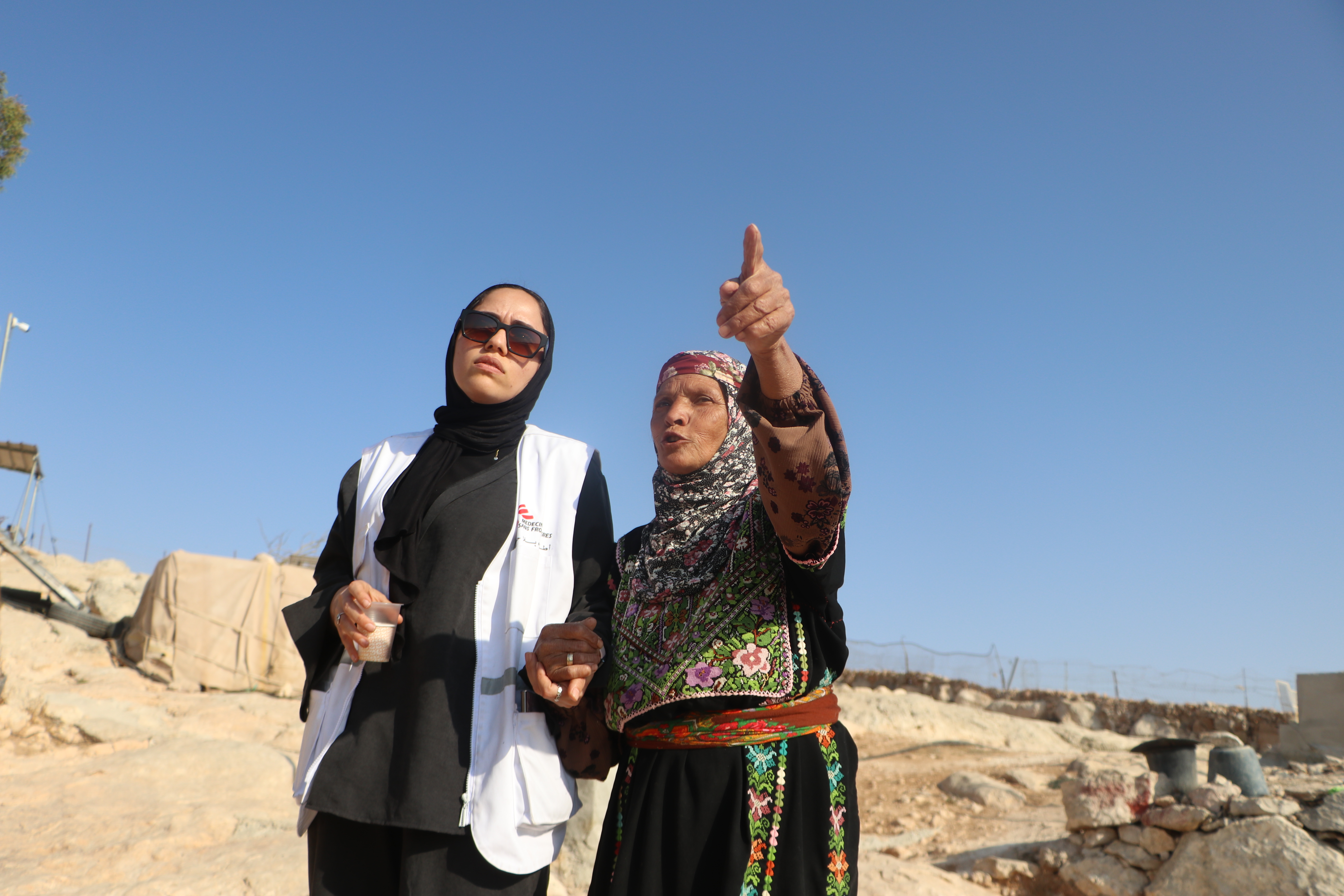 Palestijnse vrouw en medewerkster van Artsen Zonder Grenzen praten en kijken ergens naar.