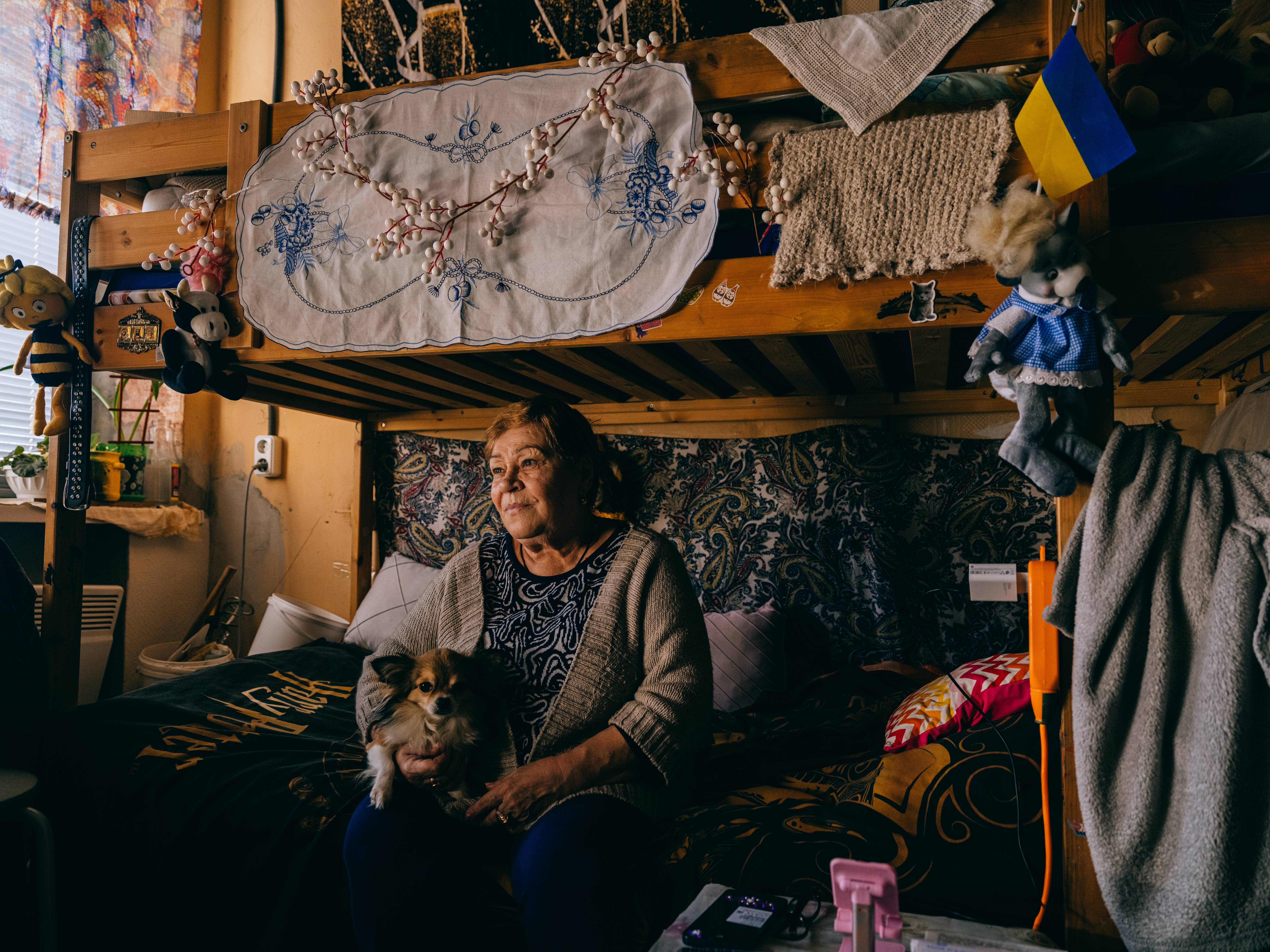 Zinaida Babisheva hugs her dog Toshyk. She is 67 years old and was evacuated from Lyman in March 2022.