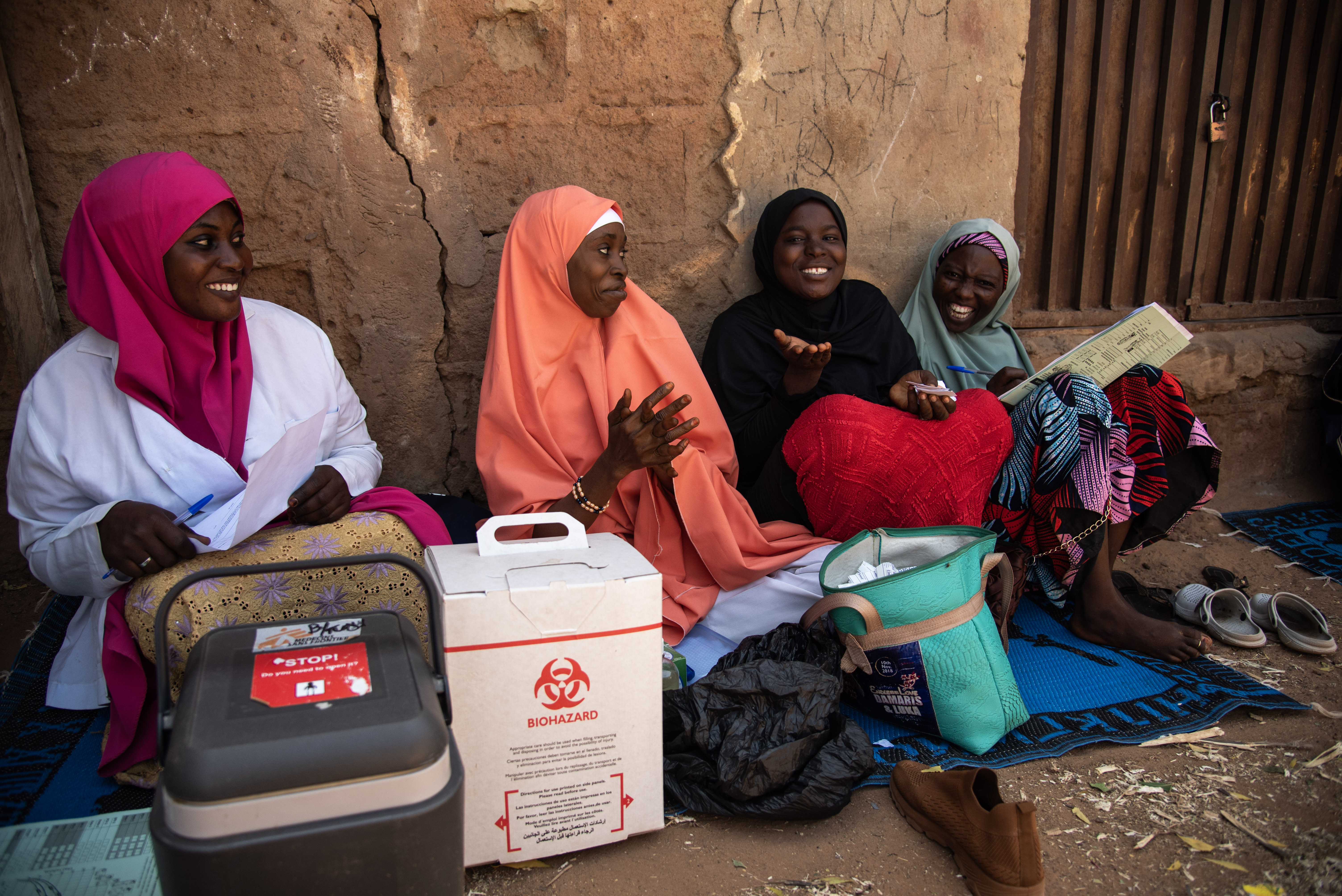 women sitting against a wall