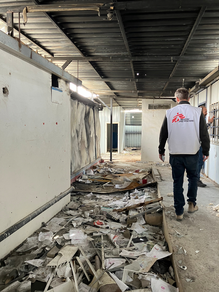 An MSF staff member is walking next to rubble