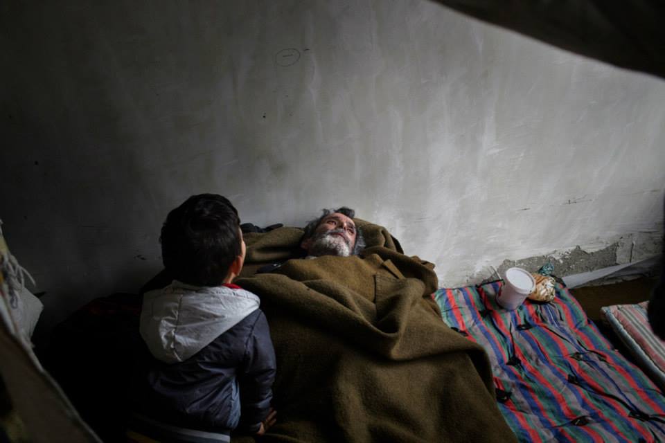 Een jongentje zorgt voor zijn zieke grootvader. © Alessandro Penso