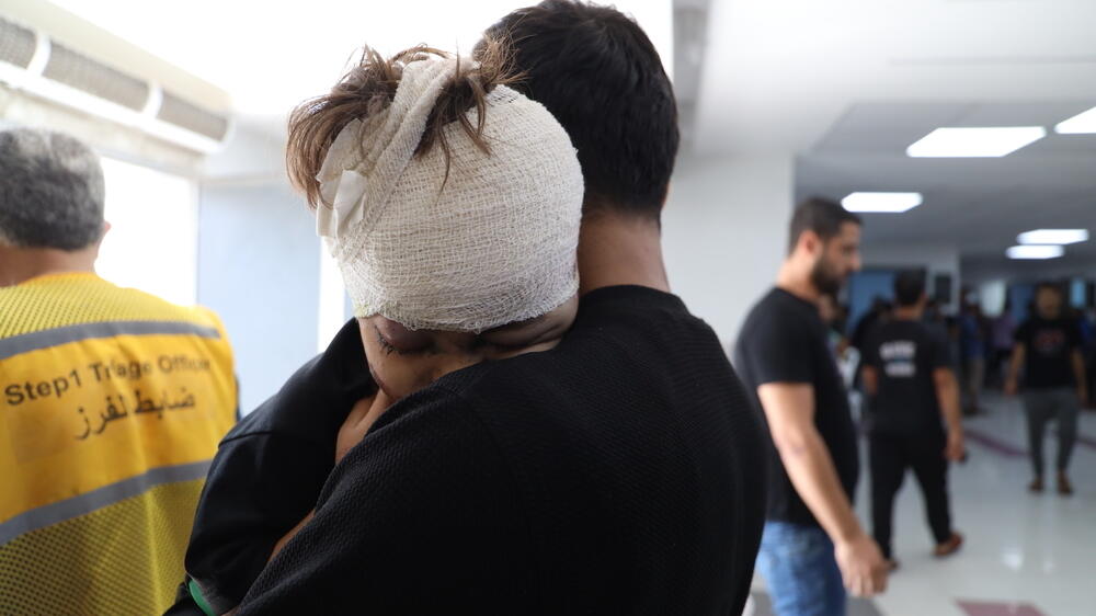 Un enfant blessé serre son père dans ses bras après avoir été soigné à l'hôpital Al Shifa.