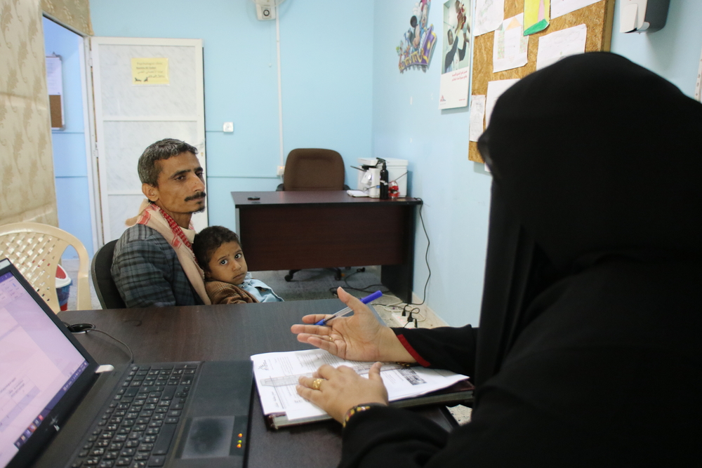 Hamdan with his son Hashid speaking to psychologist Rasmia Ali Mohammed at the mental health clinic supported by MSF at Al-Gamhouri Hospital in Hajjah, Yemen.
