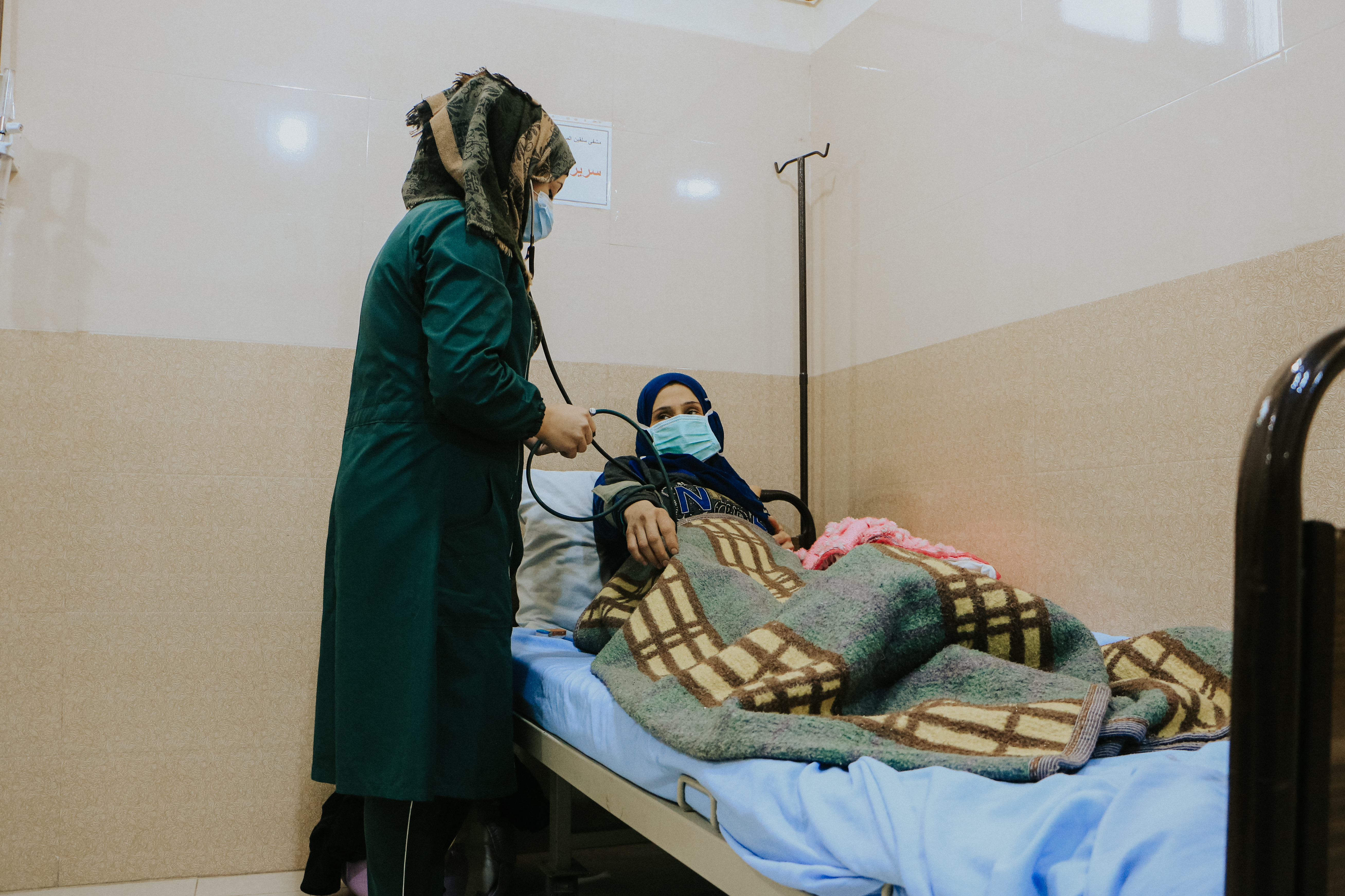 Een verpleegster onderzoekt een ontheemde vrouw die is bevallen in een ziekenhuis dat mede beheerd wordt door Artsen Zonder Grenzen in het gouvernement Idlib, in het noordwesten van Syrië. 