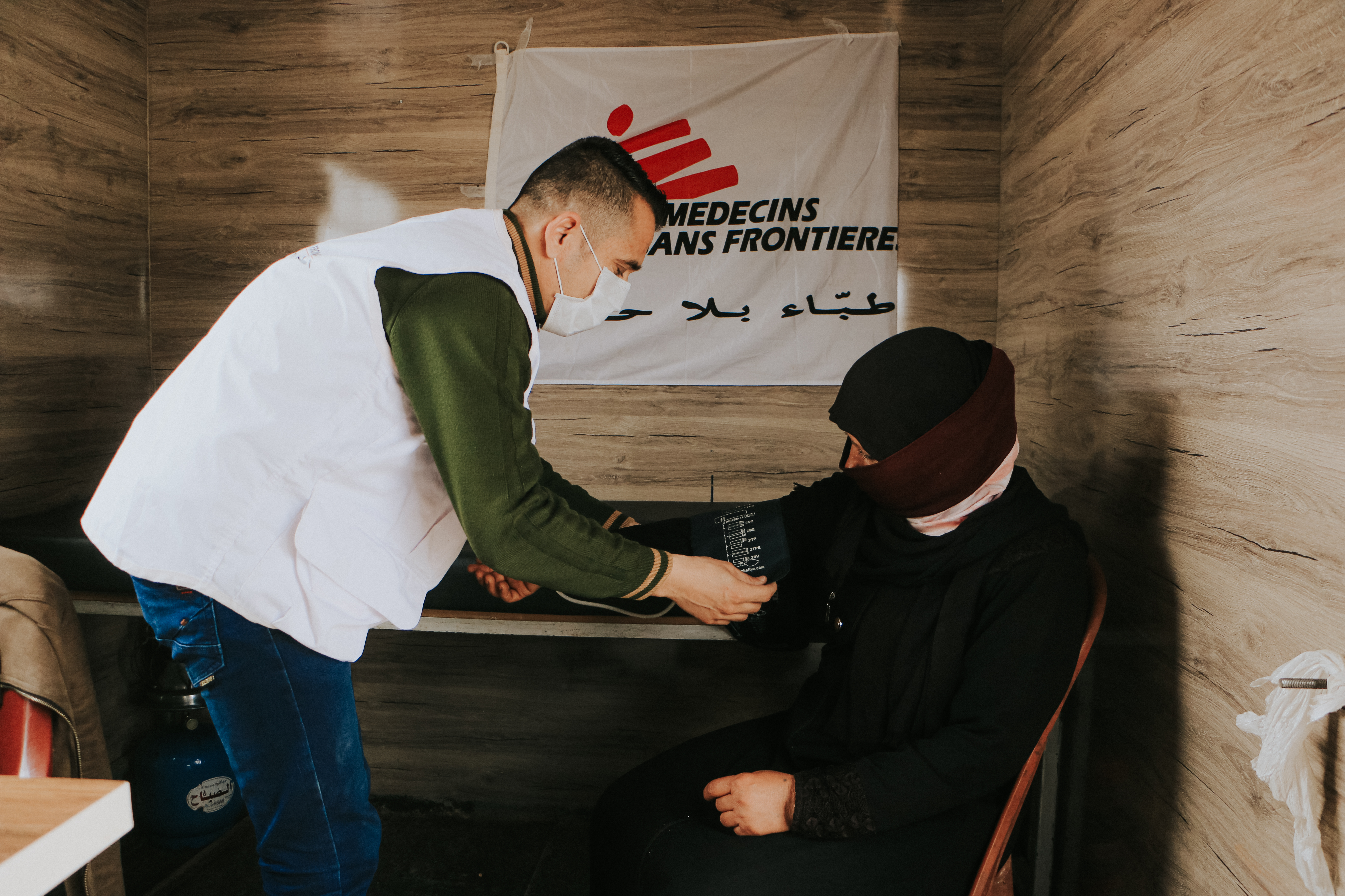 A health worker from the Artsen Zonder Grenzen checks the blood pressure of a female woman in a mobile clinic of the Artsen Zonder Grenzen during a visit during a fight in the public government of western Syria.