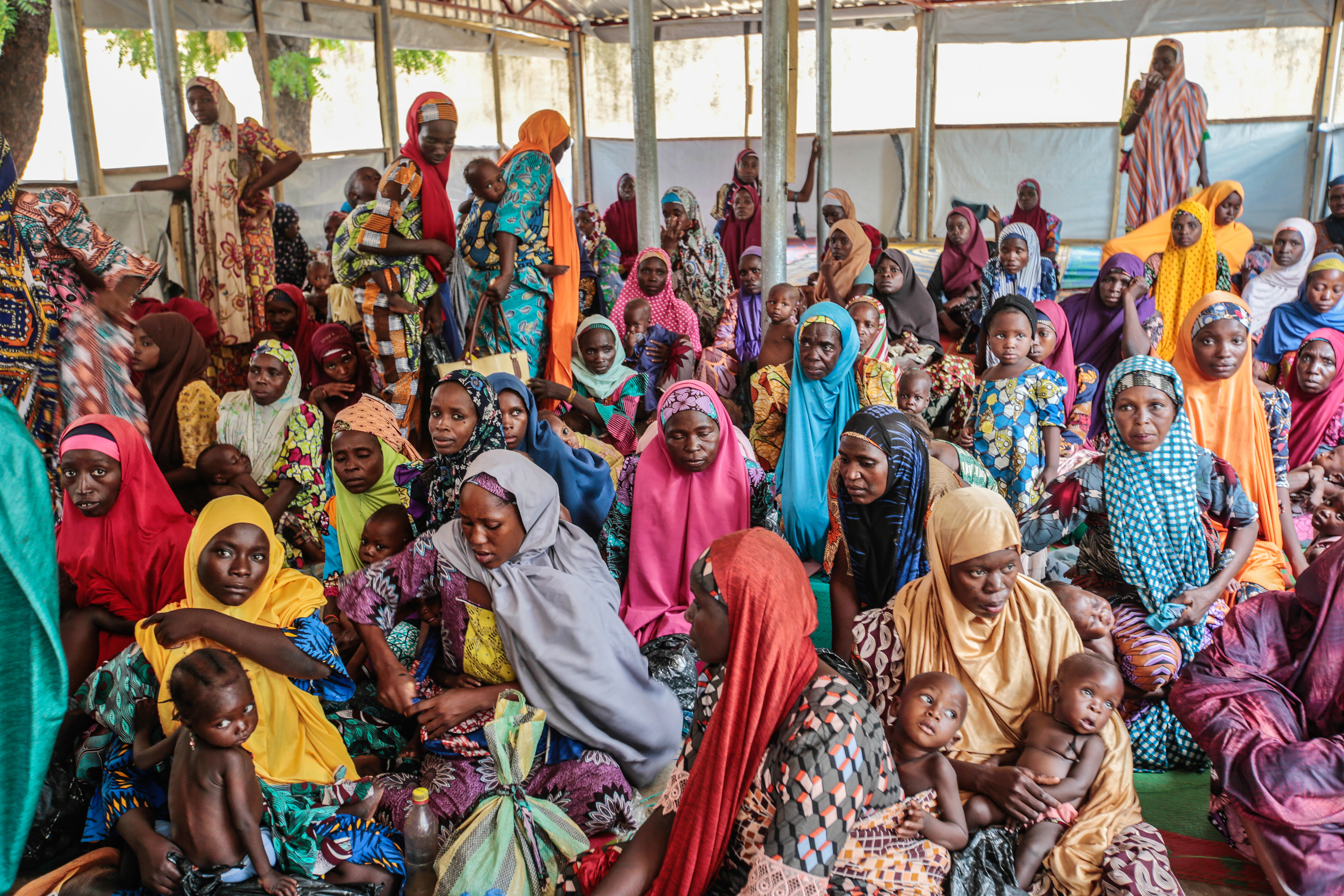 Des enfants et leur mère attendent à l'ATFC de Kofar Marusa, dans l'État de Katsina, au Nigeria, en juin 2022. 