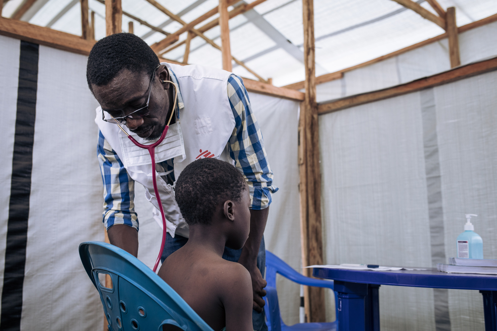 Dr. Padoue Kamamba Nawej, an MSF doctor, consults a child in the MSF's mobile clinic at Rugabo Stadium,