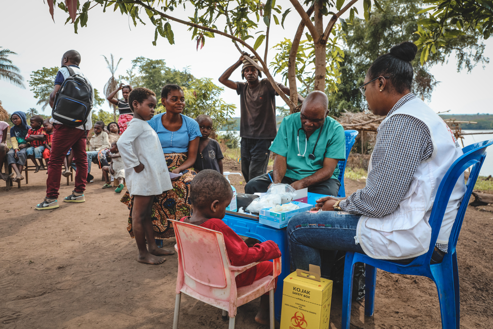 Madukila Marthe (in het blauw), 29 jaar, vluchtte met haar kinderen voor het geweld en kwam aan op de site van de Hervéboerderij in Kwamouth. Ze bracht haar kinderen mee naar een mobiel medisch consult van AZG. 