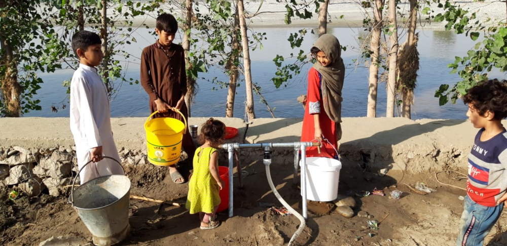 De kinderen van het dorp Miaonlay, Charsadda, provincie Khyber Pakhtunkhuwa, halen schoon water uit het waterfiltersysteem dat AzG in het dorp heeft geïnstalleerd. 