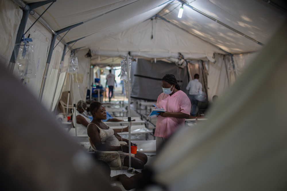 Haïti CTC Turgeau - Een verpleegster raadpleegt de moeder van een kind dat aan cholera lijdt in het cholerabehandelingscentrum (CTC) dat in het noodcentrum van AzG in Turgeau is geïnstalleerd. MSF heeft sinds de opleving van de cholera begin oktober ongeveer 150 personeelsleden aangenomen om het toenemende aantal zieke patiënten op te vangen. 