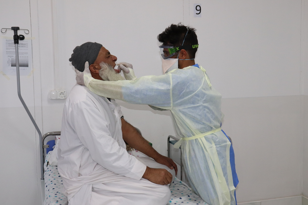 Norrulah Nasrat, infirmier MSF, prélève un échantillon sur Mohammadin, un patient suspecté d'être atteint du COVID-19, dans le centre de traitement du COVID-19 de MSF à Herat, en Afghanistan. © Waseem Muhammadi