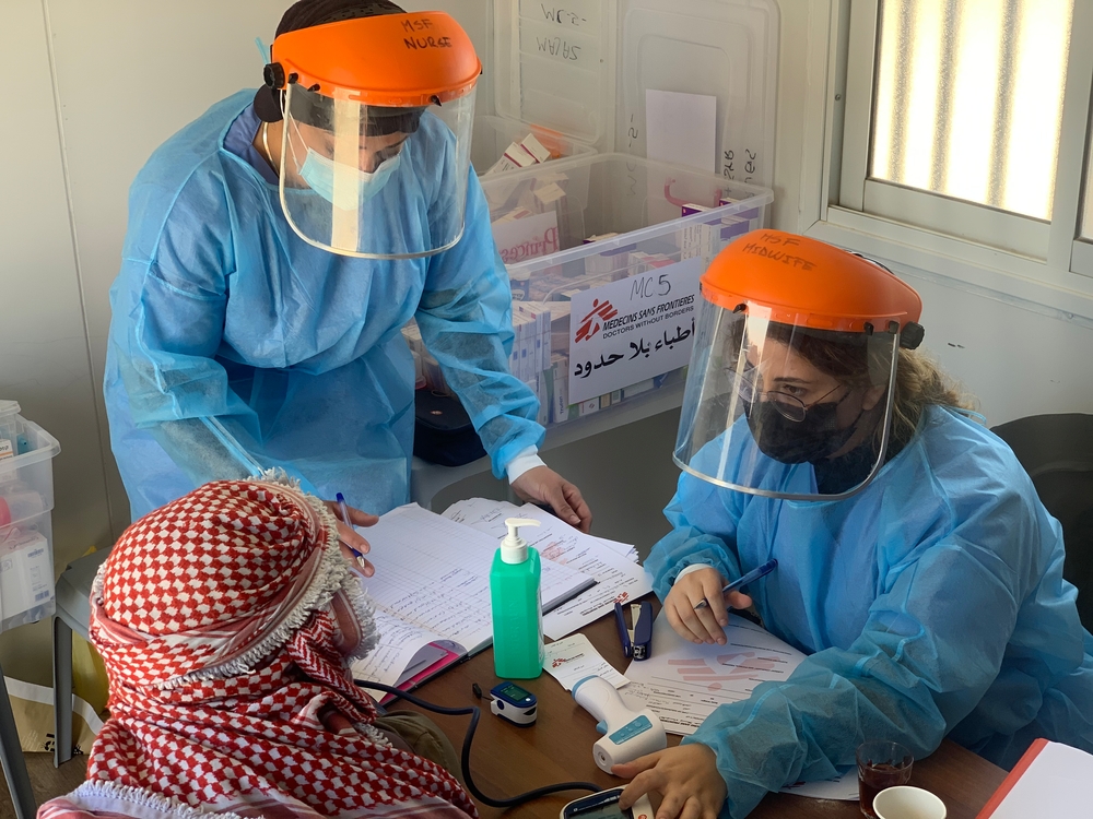 Twee medewerkers zijn in overleg met een patiënt in Hebron. 