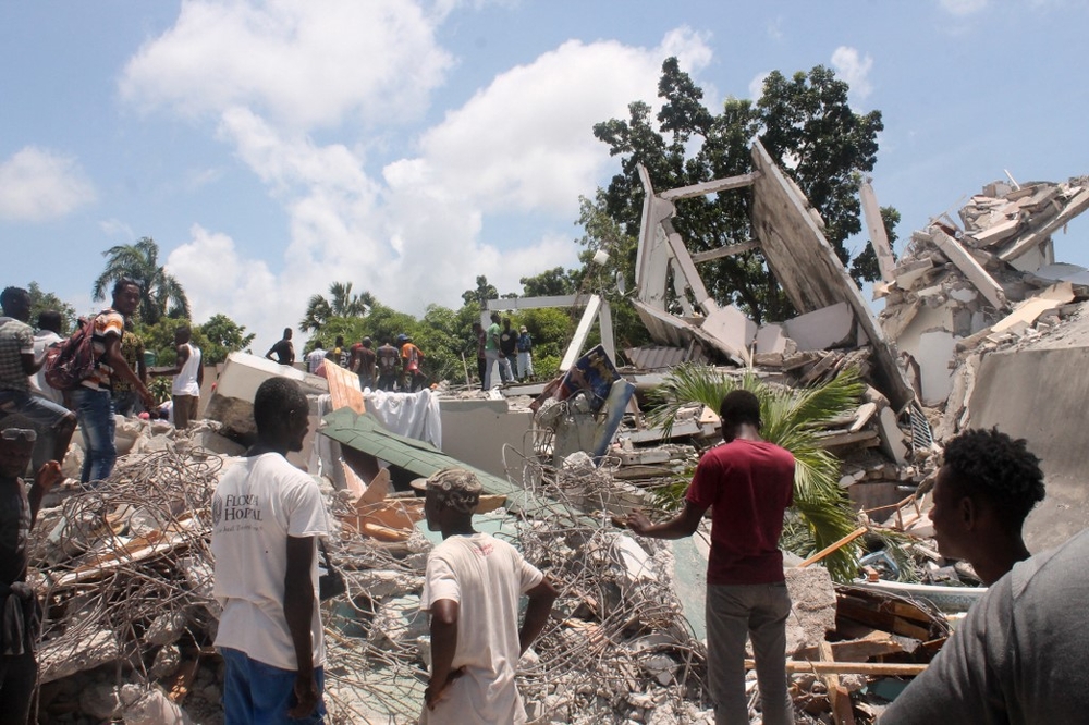 Mensen doorzoeken het puin van wat vroeger het Manguier Hotel was na de aardbeving op 14 augustus 2021 in Les Cayes, zuidwest Haïti.