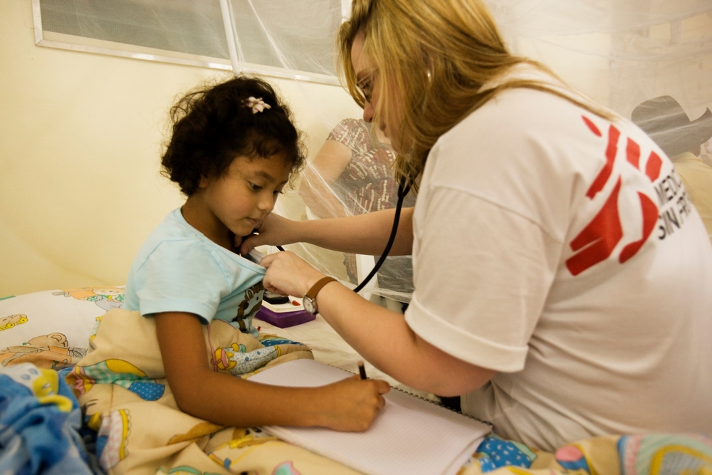 Une petite fille se fait ausculter au Honduras par un médecin MSF