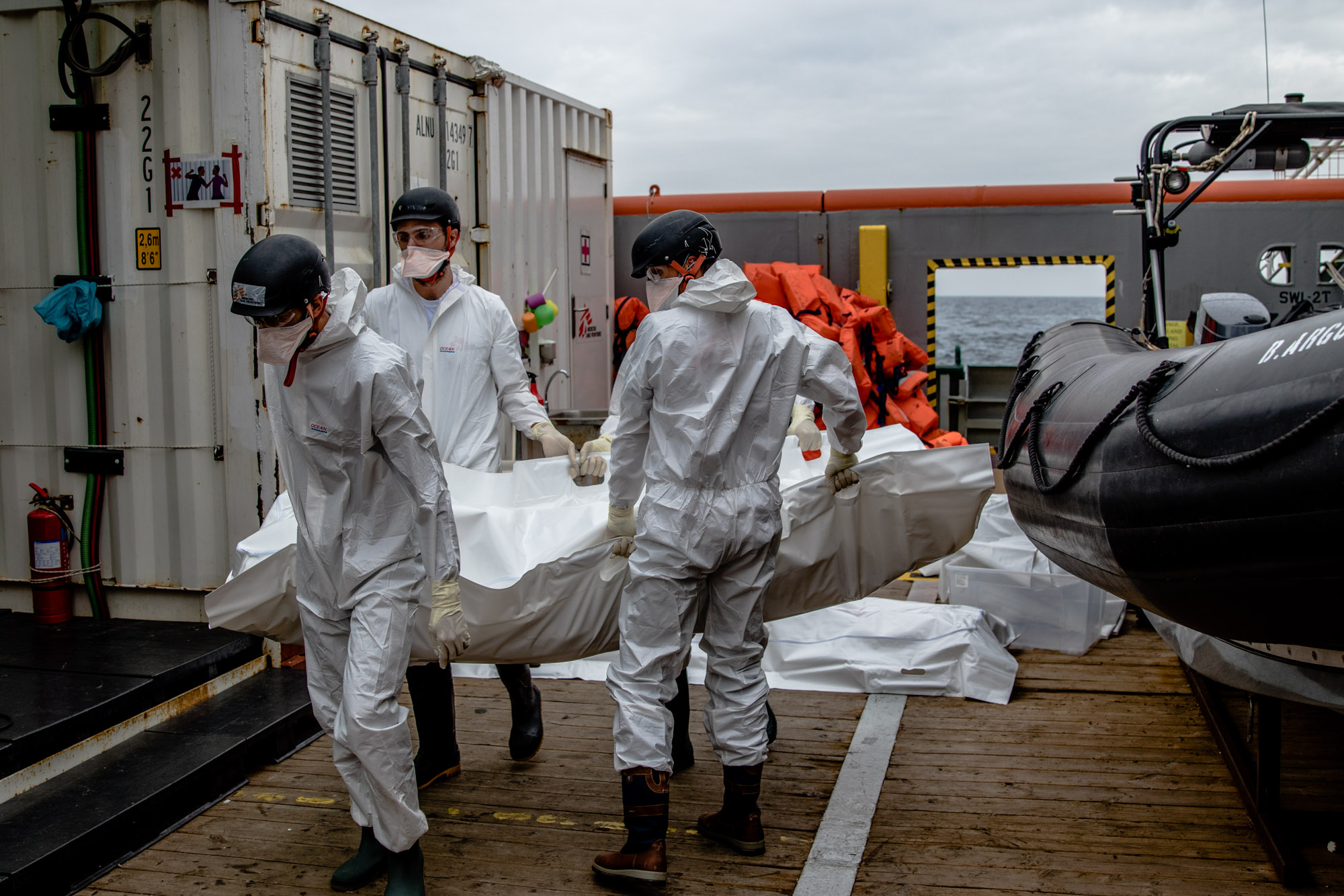 Une équipe MSF porter un corps jusqu'à la morgue du bateau sur le Bourbon Argos