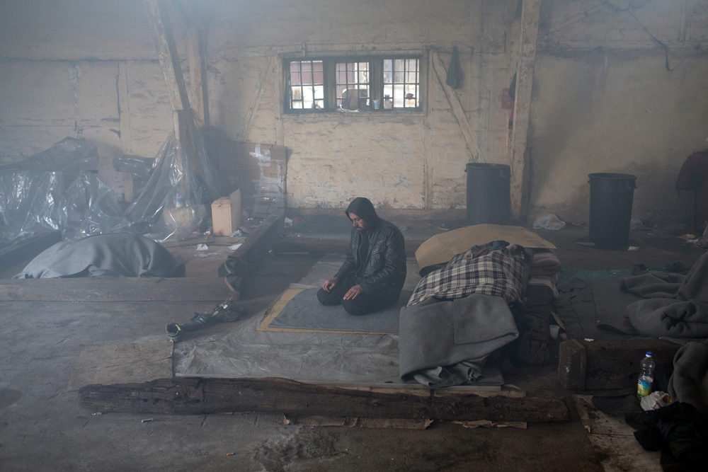 Un homme prie dansun entrepôt de Belgrade