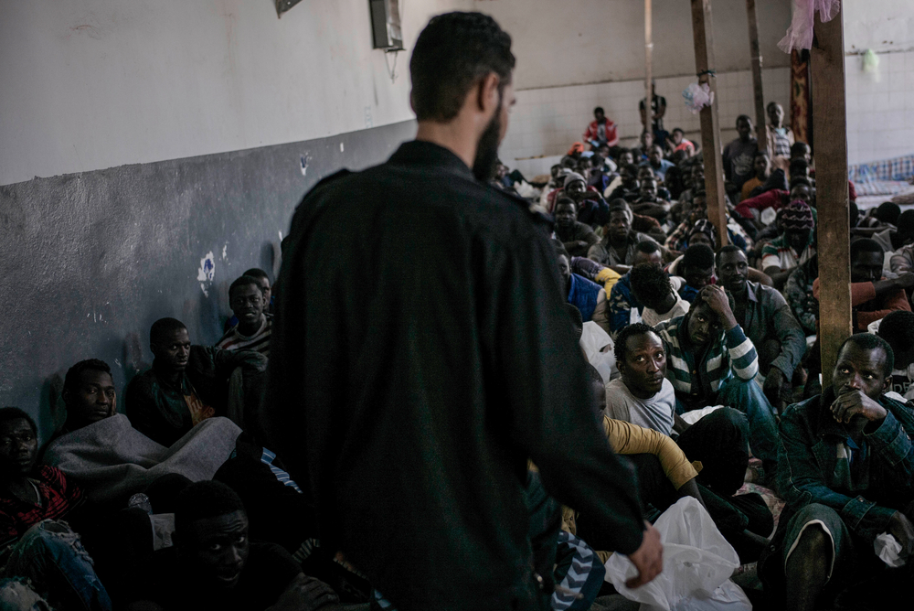 Mensen op de vlucht in Libië worden vaak ontvoerd en verkocht, of  worden opgepakt door Libische autoriteiten om naar gesloten detentiecentra te worden gebracht. Daar wacht hen totale opsluiting, mishandeling, foltering in de meest smerige omstandigheden. Sommige mensen getuigen over propvolle cellen waar vluchtelingen zelfs rechtop moesten slapen. Wie vrij wil komen, moet vaak een afkoopsom betalen. ©  Guillaume Binet, 2017