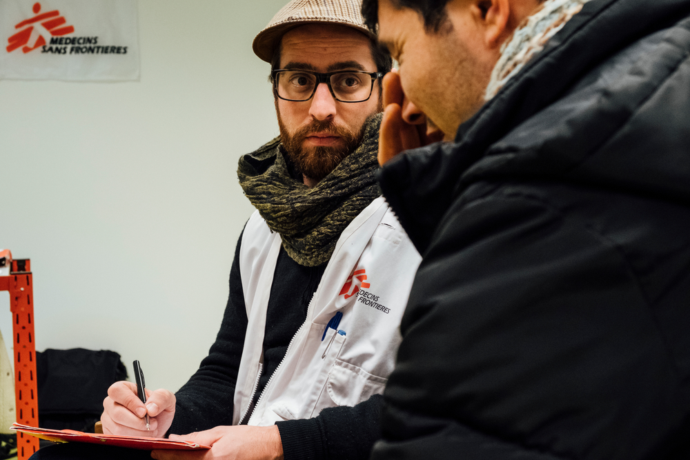 Xavier, psychologue MSF, en discussion avec un migrant à l'ancien HUB avant son déménagement à la gare du nord © Bruno de Cock / MSF