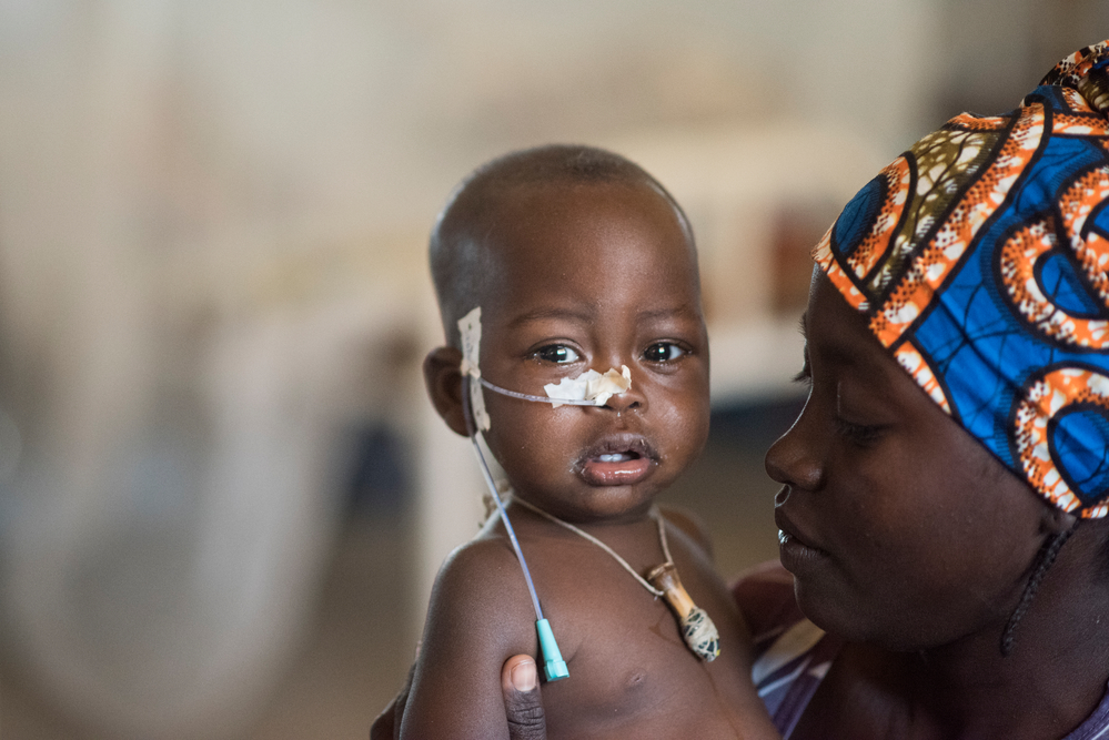 Een éénjarig kind met ademhalingsproblemen met haar moeder in het ziekenhuis in Far North. © Sylvain Cherkaoui, januari 2018.