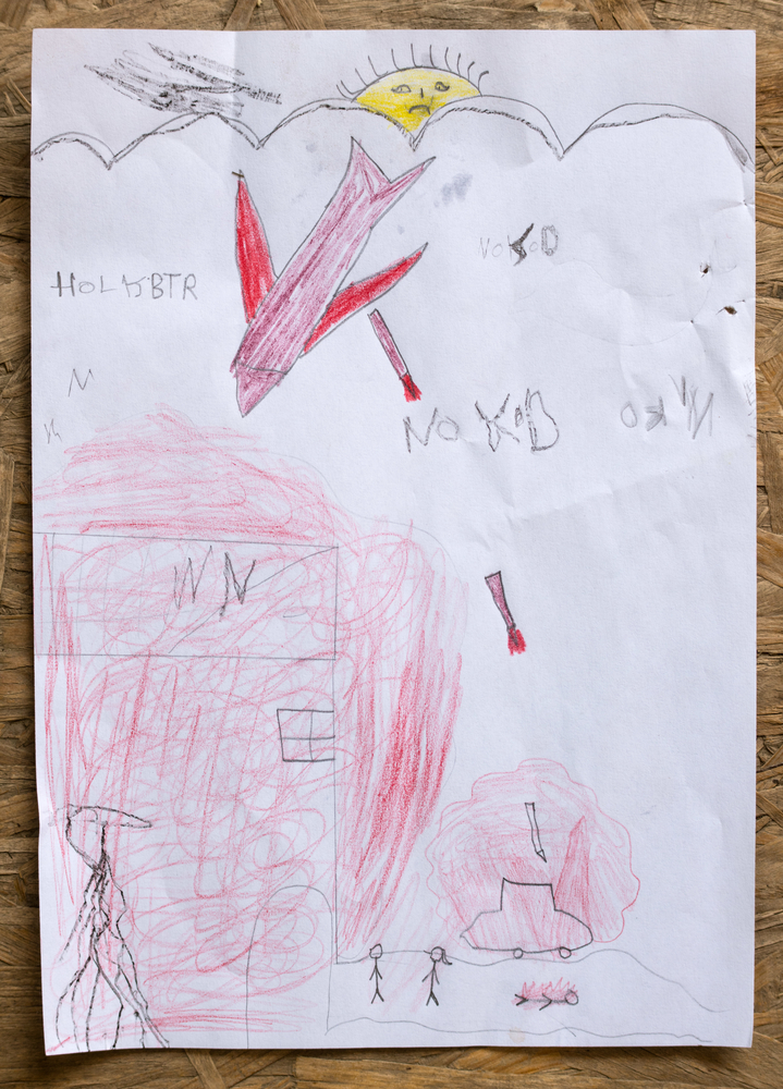 Dessin d'un enfant qui illustre la violence dans son pays d'origine. Il a dessiné des bombes, des bâtiments en feu, un soleil triste...
