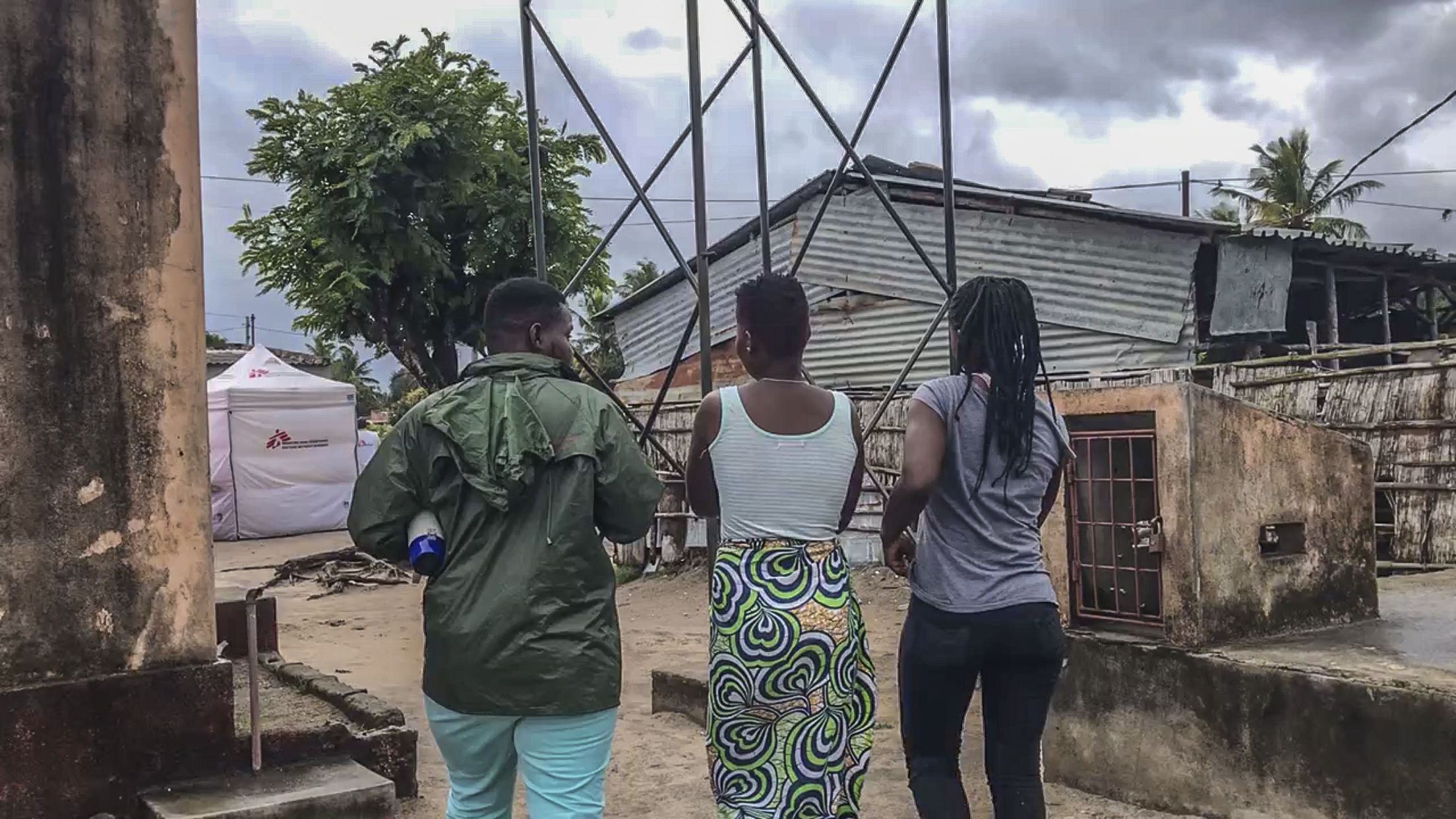 Filipe (à gauche) éducateur MSF et ancien travailleur du sexe, guide deux filles jusqu'au site de test mobile de MSF où elles pourront effectuer un test de dépistage du VIH. © Sanna Gustafsson, juillet 2018