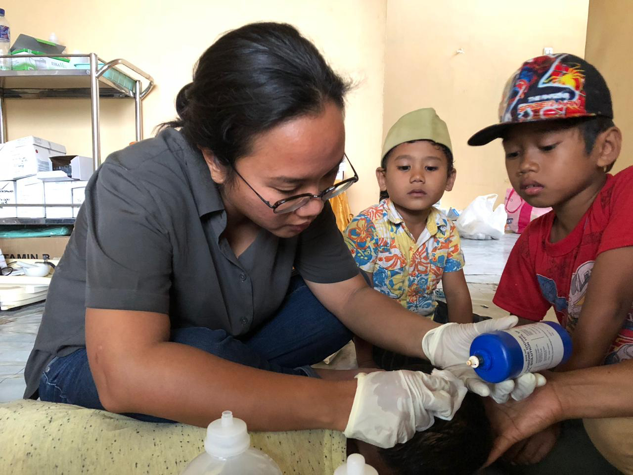 Dr Rangi Wirantika panse la plaie d'un garçon de 4 ans nommé Adam. Il s'est blessé à la tête alors qu'il fuyait lors du tremblement de terre et du tsunami dans le centre de Sulawesi, en Indonésie.