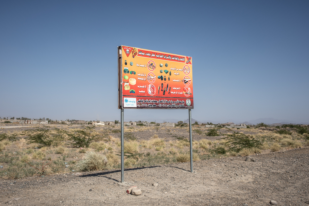 Een bord langs de weg in Mawza waarschuwt voor de aanwezigheid van landmijnen en springtuig. © Agnes Varraine-Leca, december 2018.