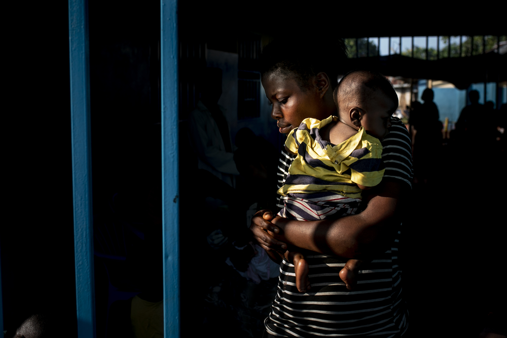 Une mère quitte le centre de santé de Lunyeka avec son enfant qui vient de se faire vacciner contre la rougeole alors qu’une épidémie fait rage. 