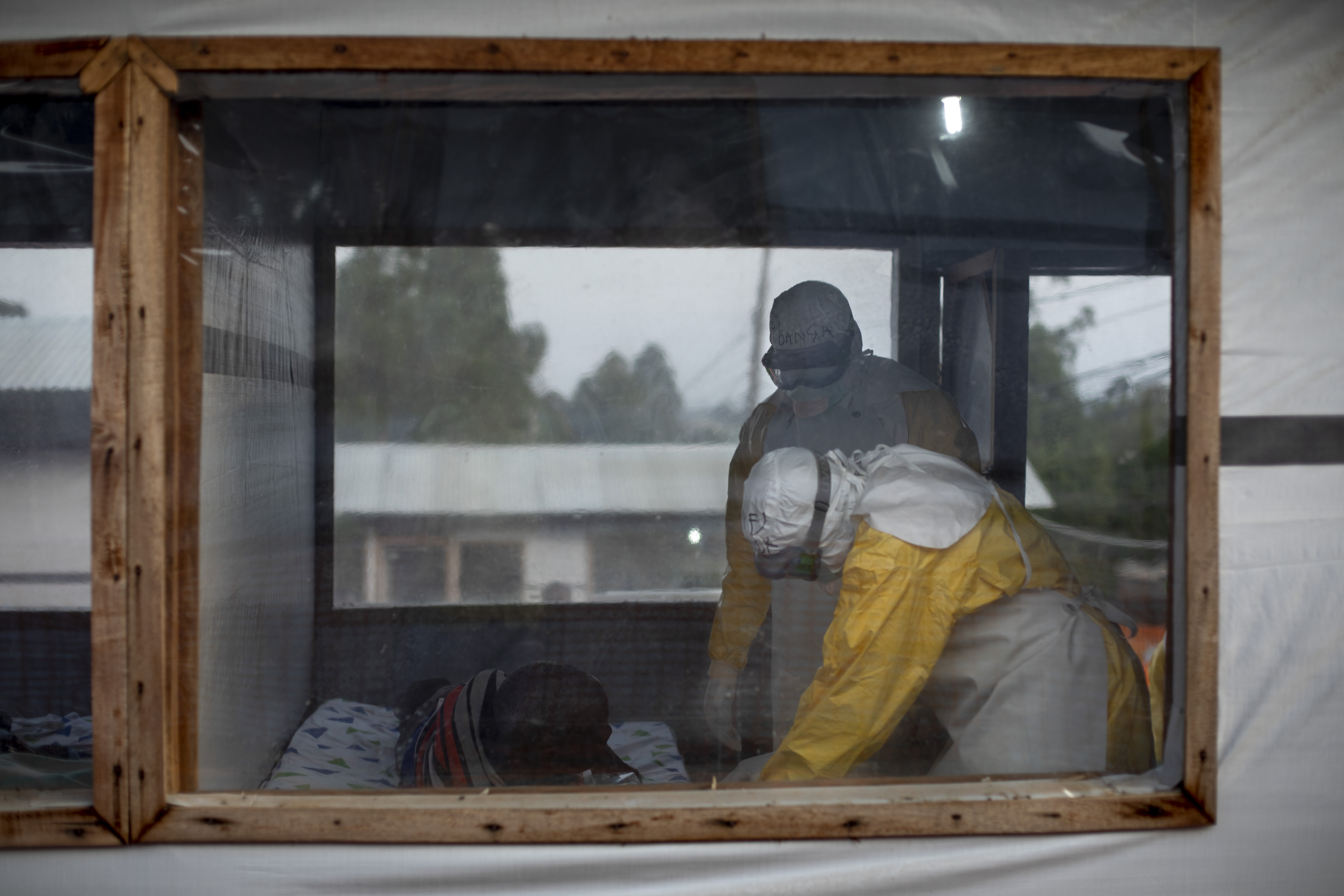 Vensters in de ebolacentra laten de familie van de patiënt toe om de verzorging van hun dierbare te volgen. Dit is een van de maatregelen die we hebben genomen om het vertrouwen bij de gemeenschap te herstellen. © Pablo Garrigos, juni 2019
