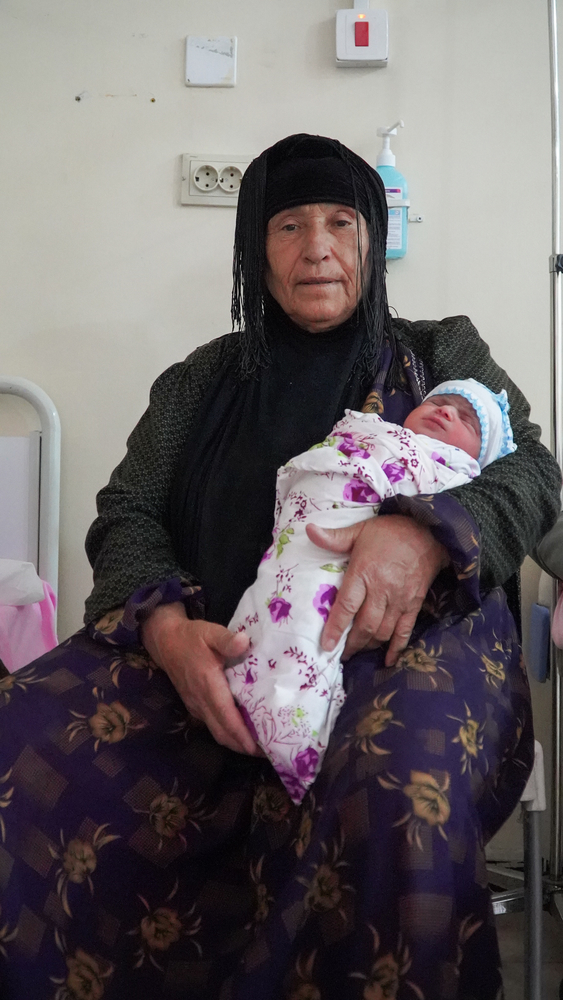 Een trotse oma met haar pasgeboren kleinkind in de armen, in de kraamkliniek van Nablus. 