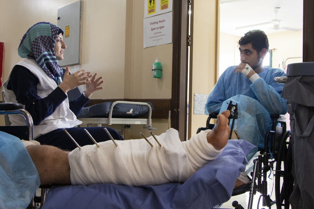 Gezondheidspromotor Amel Abed praat met een patiënt in ons ziekenhuis in Gaza.