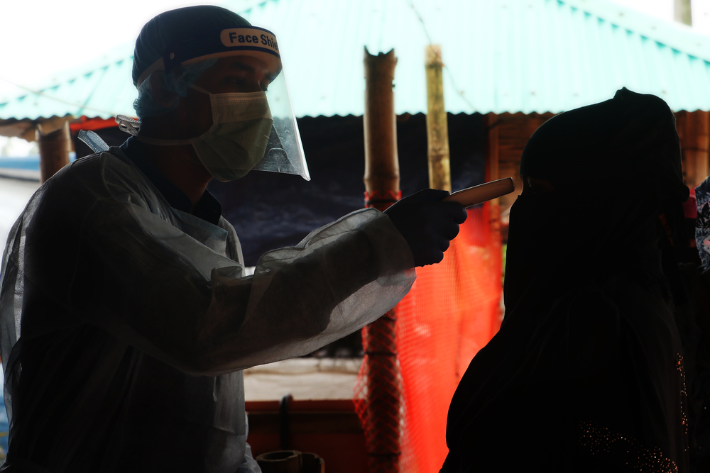 Un membre du personnel de MSF vérifie la température d'une femme à l'hôpital de Goyalmara à Cox’s Bazar, dans le sud-est du Bangladesh, dans le cadre de leurs mesures de prévention contre le COVID-19