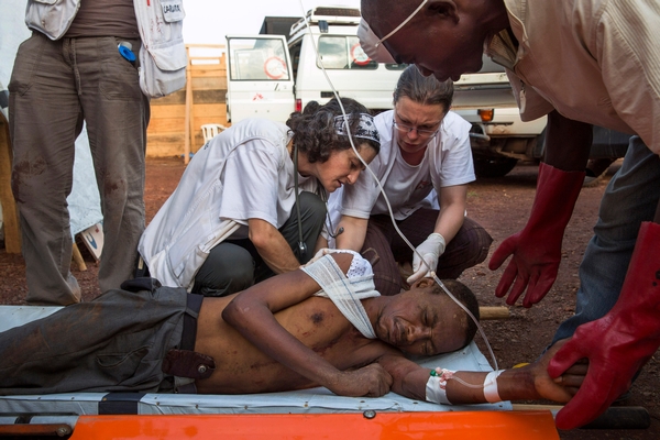 Een gewonde man in Mpoko kamp krijgt verzorging © William Daniels