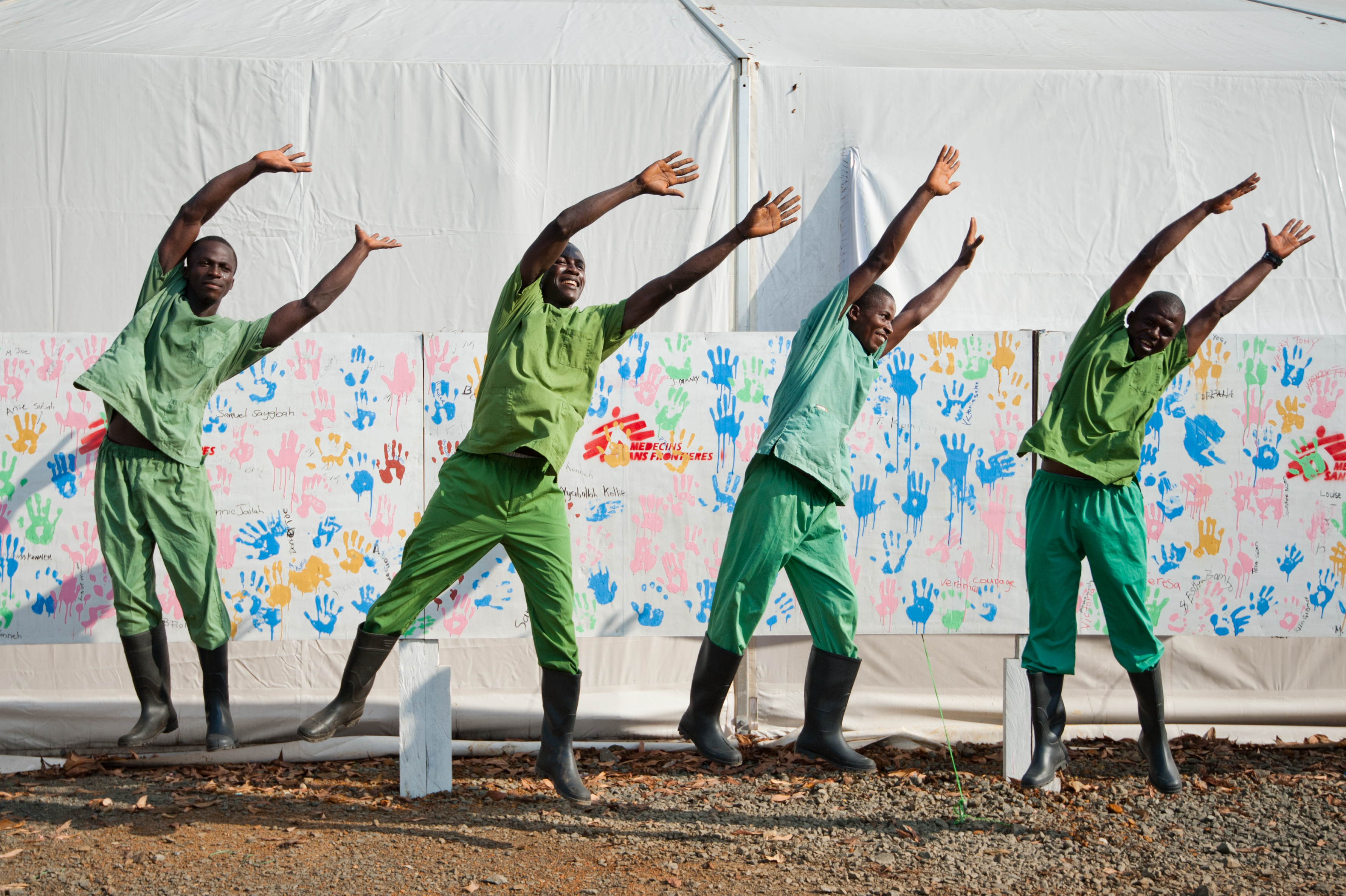 Du staff du Centre Ebola ELWA 3 devant le mur des survivants © Peter Casaer/MSF