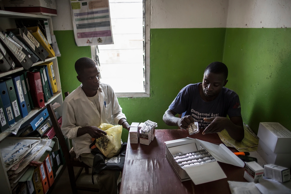 Het transport naar het lokale ziekenhuis is erg duur voor hiv-patiënten in landelijk gebieden. Daarom organiseren ze zich in groepen, waarvan telkens 1 iemand de aidsremmers voor iedereen gaat halen. © Marco Longari/AFP Photo. Malawi, 2015. 