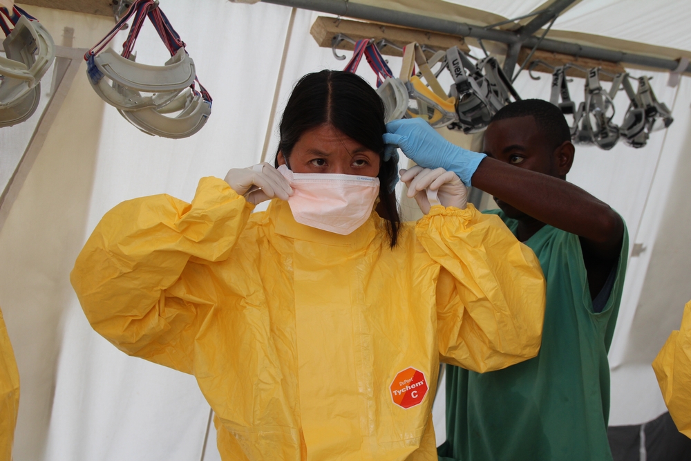 Joanne Liu trekt beschermende kledij aan om een ebolacentrum van AZG in Sierra Leone binnen te gaan. © P.K. Lee/AZG