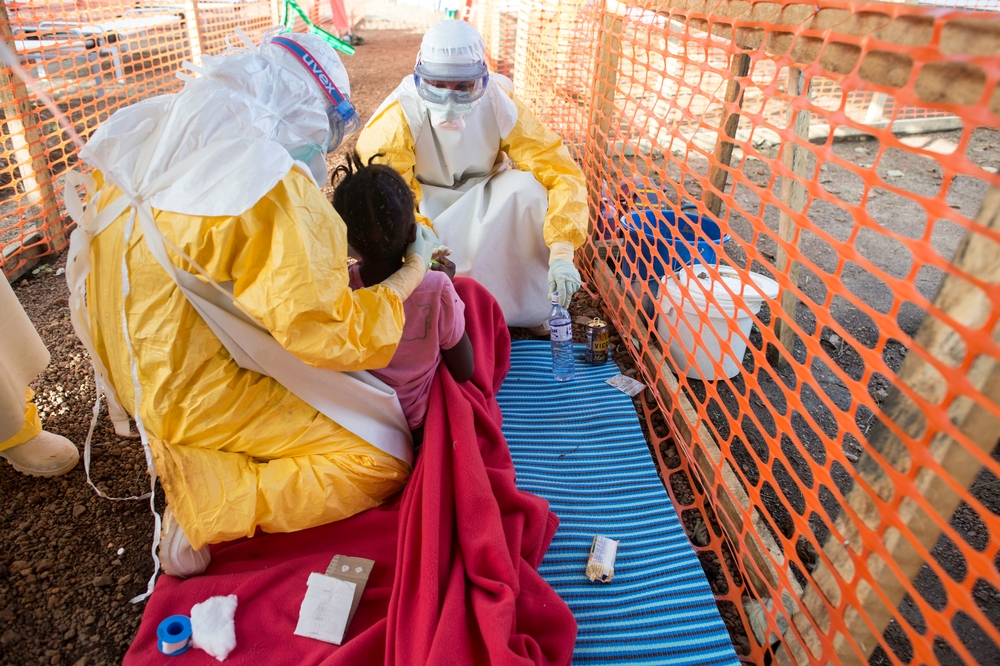Medewerkers van AZG proberen een ziek meisje te helpen met eten in de ebolakliniek in Kailahun. © Sylvain Cherkaoui/Cosmos