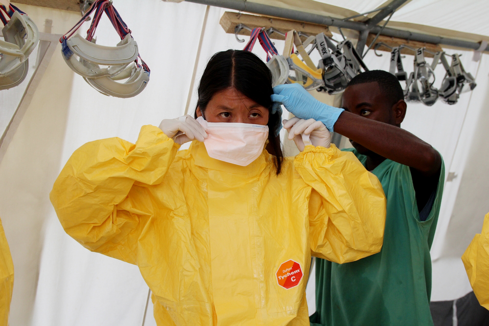 Joanne Liu trekt een beschermend pak aan om de ebolakliniek van Kailahun te bezoeken. © P.K. Lee/AZG