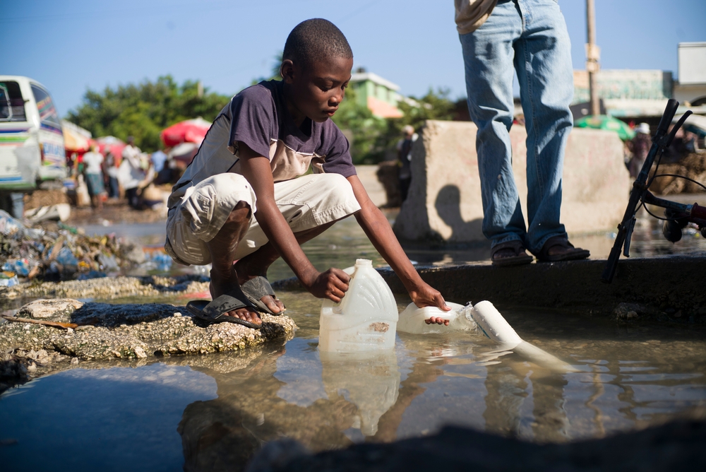 Marcus, 12 ans, récupère de l'eau pour faire sa lessive. © Corentin Fohlen