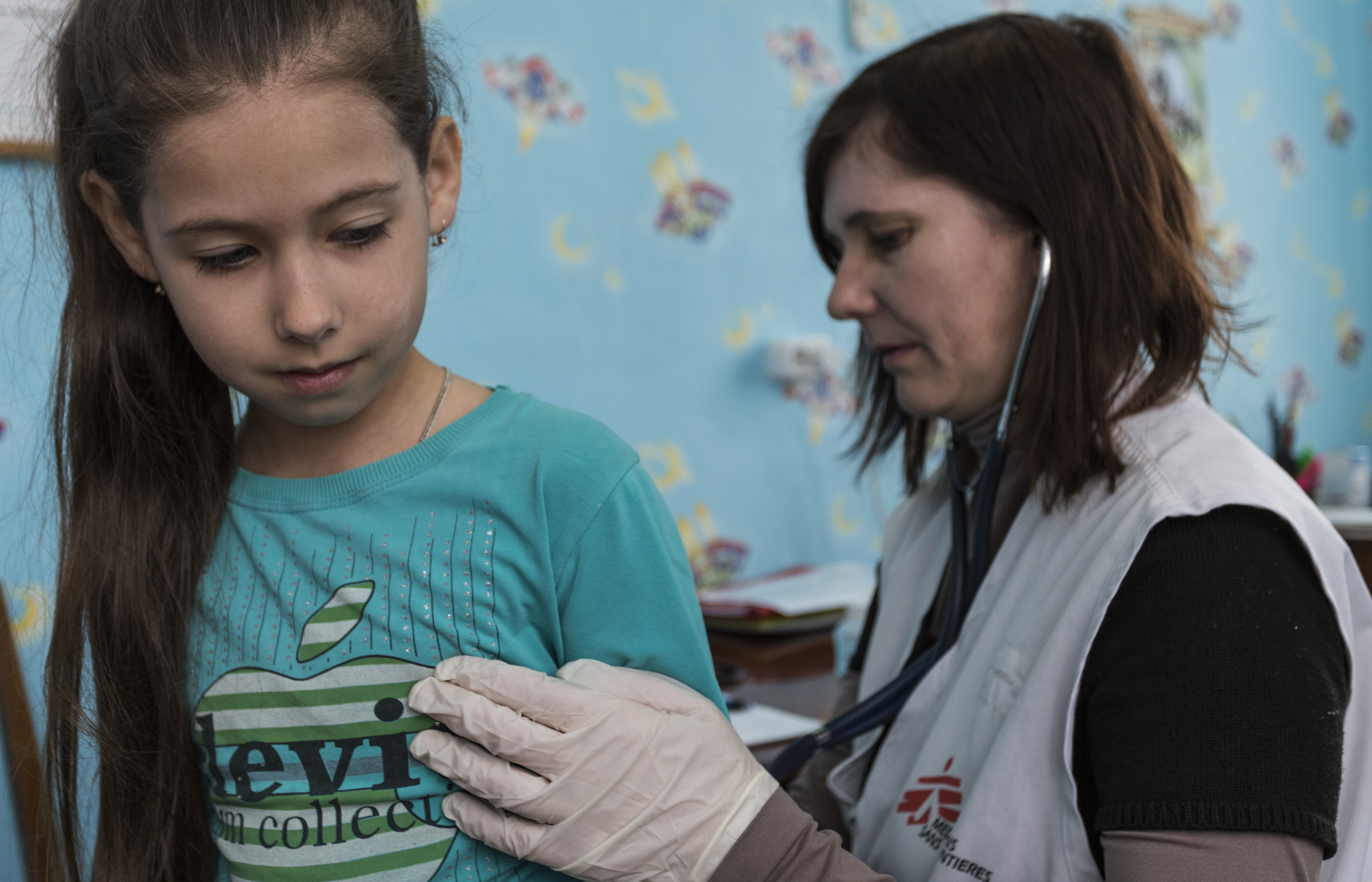 Pediater Galina Piskunova onderzoekt de achtjarige Amina in een mobiele kliniek van AZG in Zorinsk, bij Lugansk. © Jon Levy/Foto8