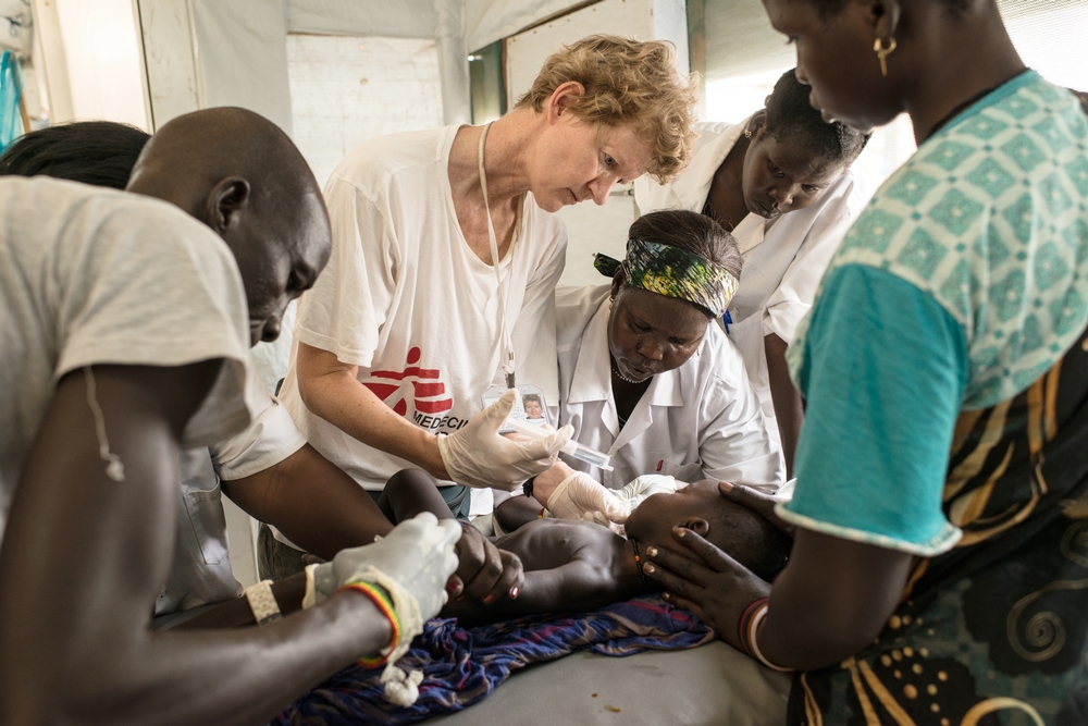 Een medisch team vecht voor het leven van een baby'tje die aan ernstige ondervoeding en uitdroging lijdt. In het Artsen zonder Grenzen ziekenhuis op een VN-terrein waar zich duizenden vluchtelingen bevinden. Foto van 1 maart 2015, Malakal, Zuid-Sudan. © Matthias Steinbach