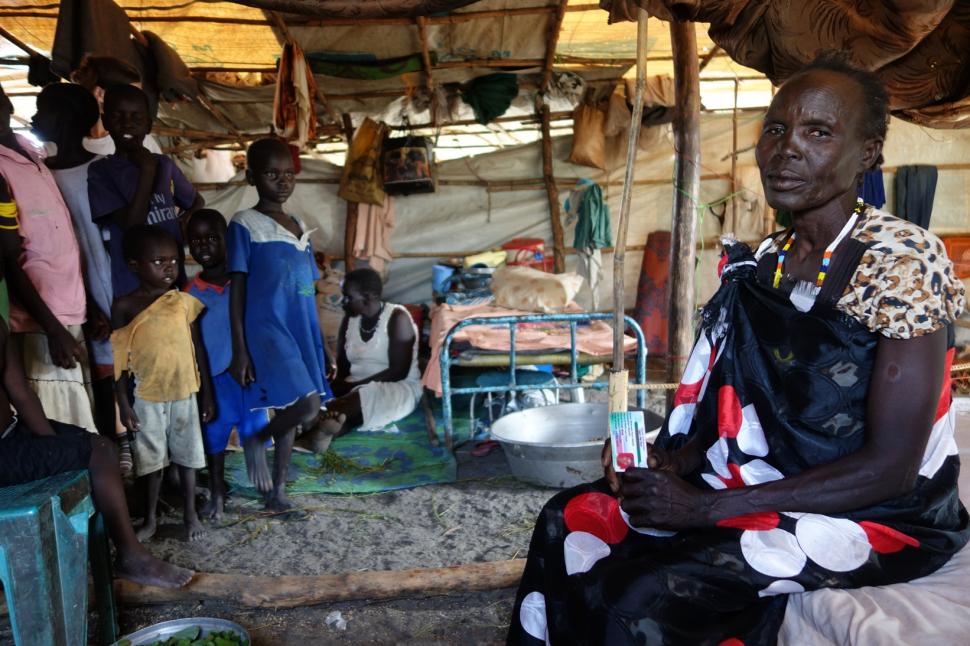 Nya vit dans une des tentes pour 50 personnes. Avant, elle travaillait comme sage-femme et habitait une maison de la classe moyenne, mais depuis qu'elle a fui le conflit dans sa ville natale, elle et ses deux fils sont presque totalement dépendants de l'aide humanitaire. En dépit de ses circonstances, Nya a pris sous son aile quatre autres enfants qui ont été séparés de leurs parents pendant la crise. Ensemble, ils partagent un lit sans matelas et deux petits tapis au sol. La zone que l’on voit dans cett