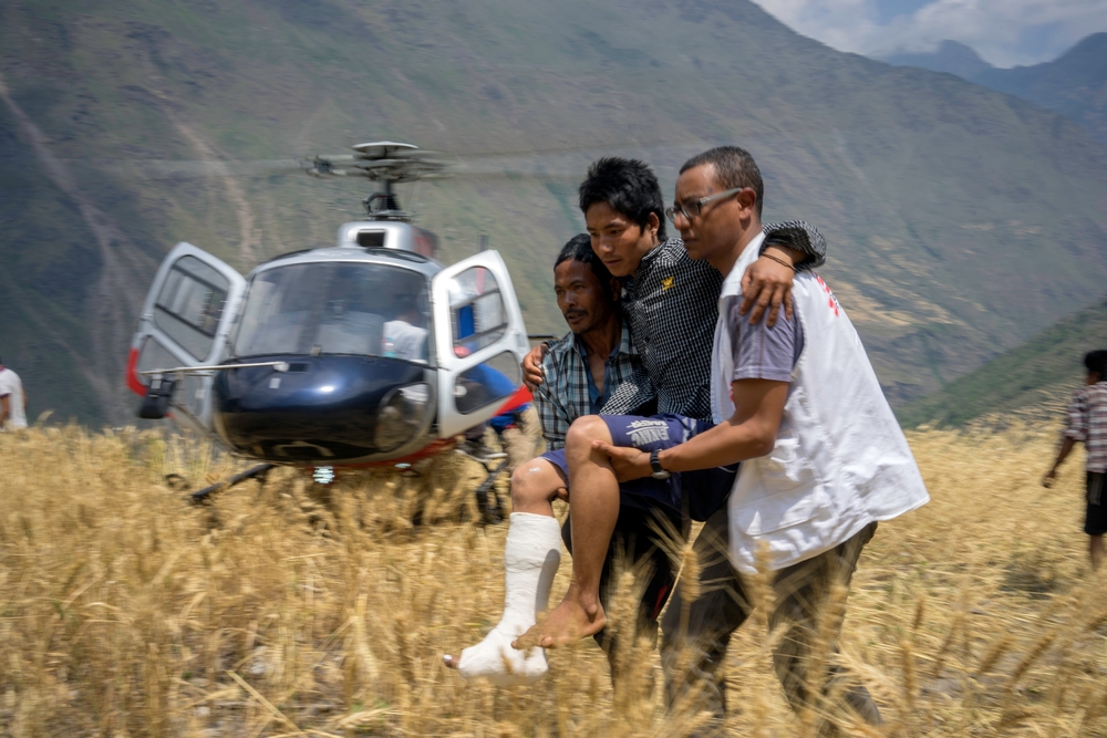 Een team van Artsen Zonder Grenzen brengt een patiënt na verzorging terug naar zijn dorp Diol, dat door de aardbeving alleen nog per helikopter bereikbaar was. © Brian Sokol/Panos Pictures. Nepal, 2015.