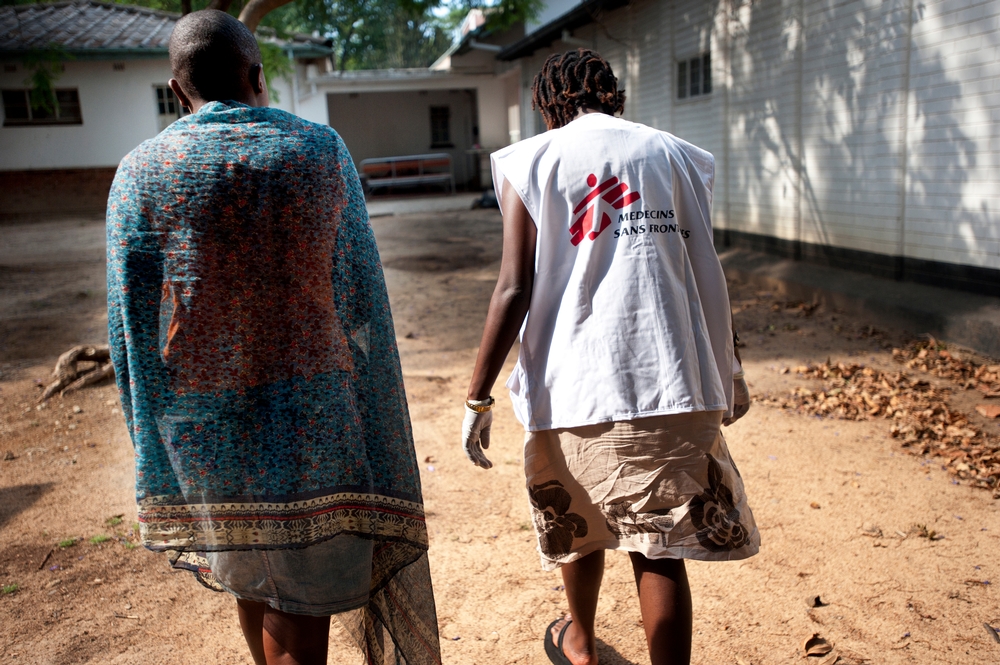 Une infirmière marche avec une victime de violence sexuelle vers la clinique spécialisée de Médecins Sans Frontières à Mbare, pour lui venir en aide © Julie Remy/MSF. Zimbabwe, 2013.   