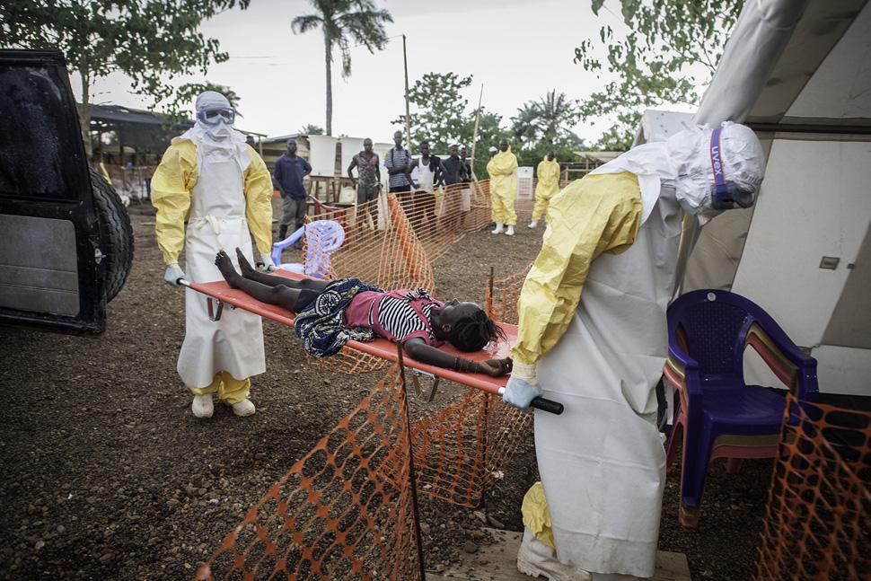 Een zieke die in contact is geweest met mensen die met ebola zijn besmet wordt binnengebracht in de Artsen zonder Grenzen ebolakliniek in Kailahun, Sierra Leone. © Sylvain Cherkaoui/Cosmos