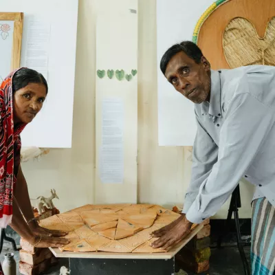 De Rohingya-keramisten Bishi Bala Rudro en Kali Kumar Rudrio staan naast hun kunstwerken.