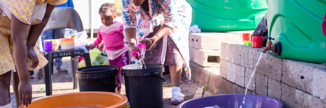 des femmes en afrique du sud prennent de l'eau dans un tonneau