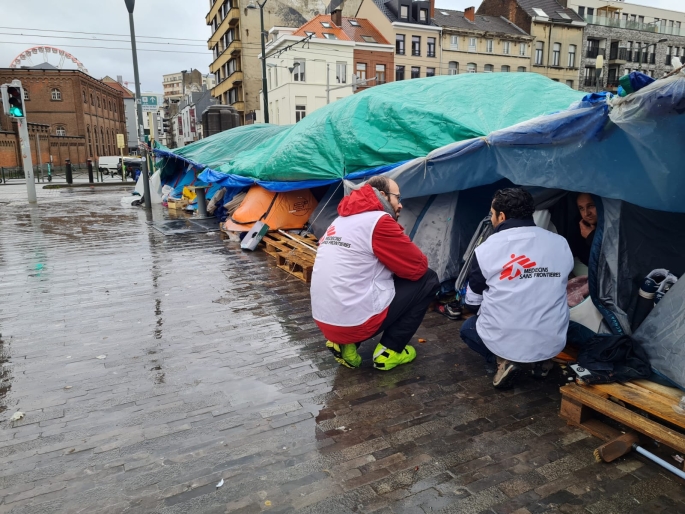 L'équipe MSF s'agenouille devant le camp de tentes à Bruxelles