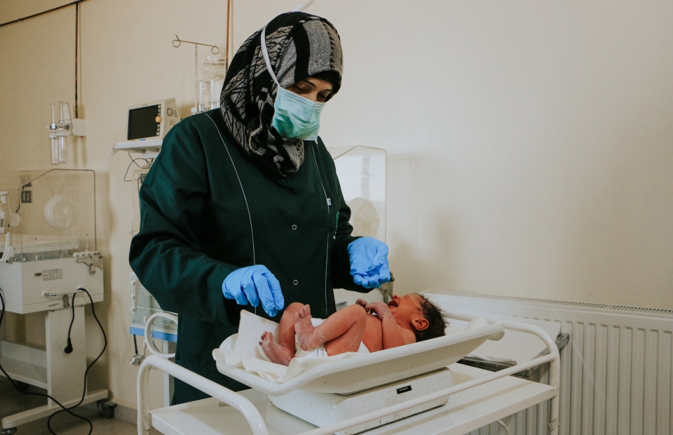 Een vroedvrouw van Artsen Zonder Grenzen onderzoekt een pasgeboren baby in de couveuse in een ziekenhuis dat mede wordt beheerd door Artsen Zonder Grenzen in het gouvernement Idlib, in het noordwesten van Syrië. 